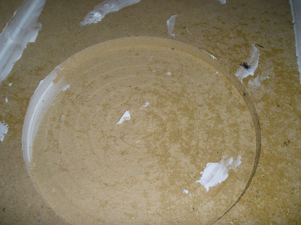 Circular recess cut into MDF board with white glue smears around it