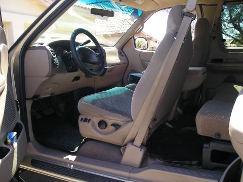 1999 Ford F-150 - Interior view of a 1999 Ford F-150, showing the dashboard, seats, and door panel.