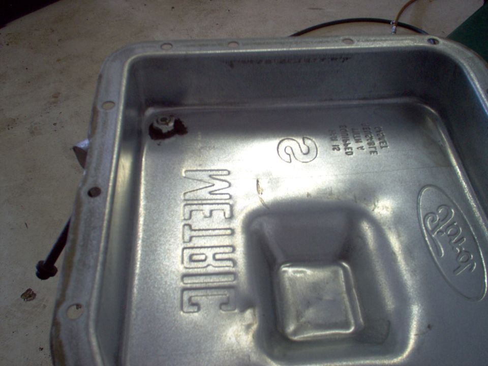 After a few hundred miles, I dropped the pan, changed the filter & gasket (it was leaking), and added a [url=http://www.amazon.com/dp/B000CO96EK/]Dorman HELP! 65128 drain plug kit[/url] to the pan.  In addition to the supplied nylon washer, I sealed around the drain with [url=https://www.amazon.com/dp/B000HBM4FQ]25224 RightStuff[/url] (same as [url=https://www.amazon.com/dp/B0002UEN1U]82180 UltraBlack[/url]), and I used a chisel to lock the nut to the tube.