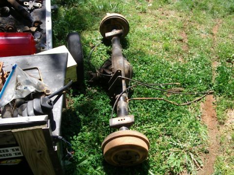 1985 Ford Bronco - A rear axle assembly with drum brakes is shown outdoors on a grassy surface.