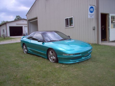 1993 Ford Probe - This 1993 Ford Probe is a teal sports coupe with a black roof, seen parked in front of a garage.