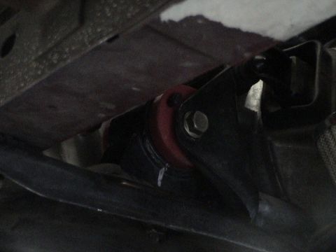 1997 Ford Probe - Underside view of a vehicle's suspension system, focusing on a red bushing and mounting hardware.