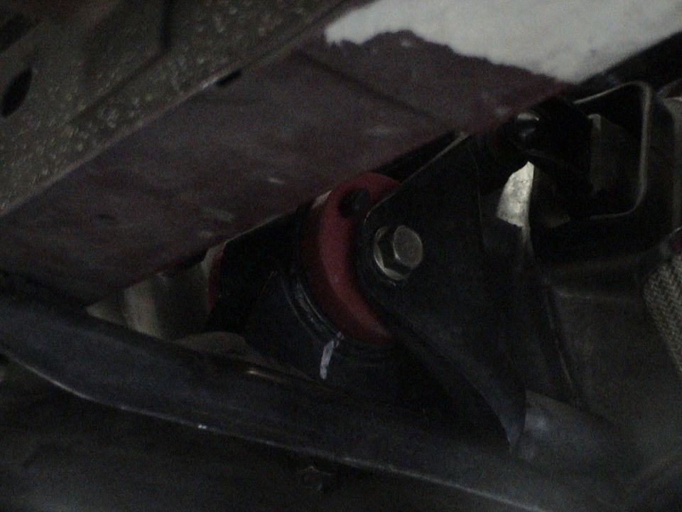 close-up of red suspension bushing and metal bracket