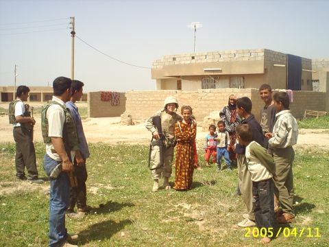 1988 Mercury Sable - A group of soldiers interact with children and locals in a village setting.