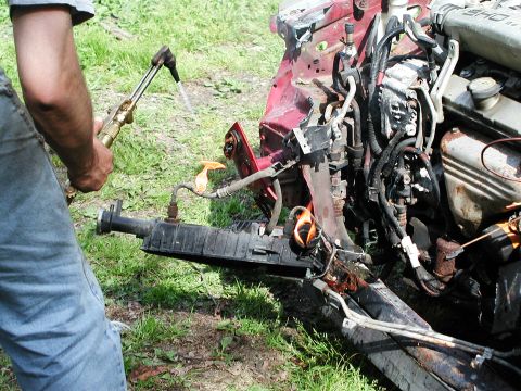 1992 Ford Taurus - A person uses a cutting torch on the front end of a 1992 Ford Taurus.