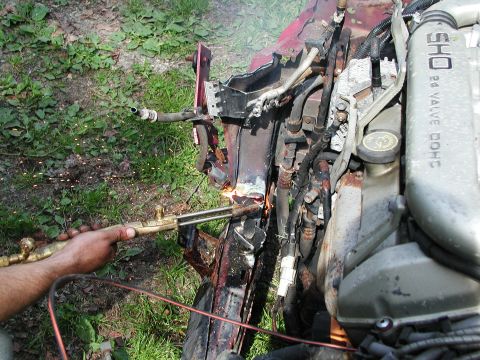 1992 Ford Taurus - Cutting engine parts with a torch. "SHO 24 VALVE DOHC" is visible on the engine cover.