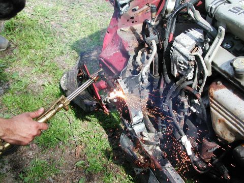 1992 Ford Taurus - A person uses a cutting torch on the damaged front section of a vehicle.