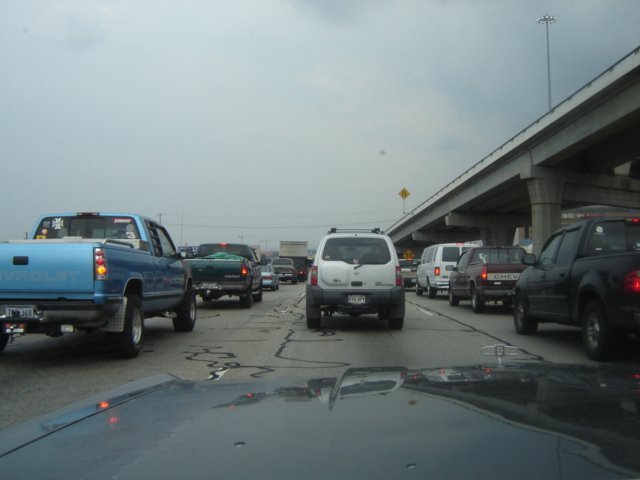 Cars stuck in traffic on a highway under an overpass. Cloudy day