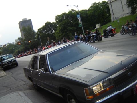 1988 Ford Crown Victoria LTD - A 1988 Ford Crown Victoria LTD is seen parked on a street with a motorcycle rally in the background.