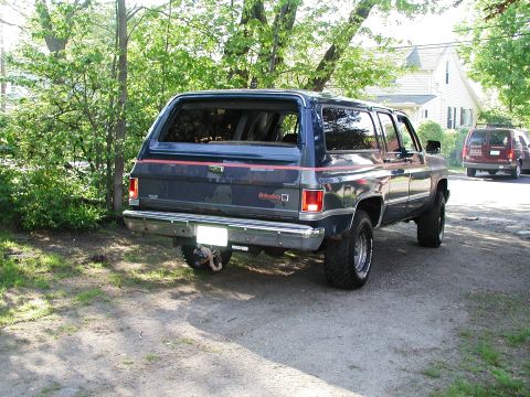 1992 Ford Taurus - A dark blue SUV with red pinstripes is parked on a gravel driveway, with another vehicle visible in the background.