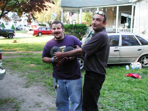 1992 Ford Taurus - Two men are in a yard with a silver sedan parked behind them.