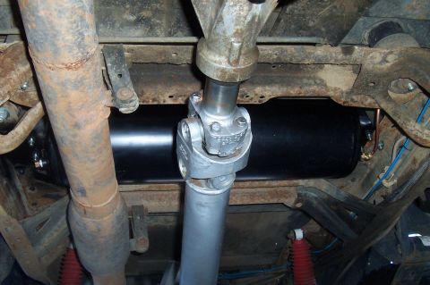 1994 Ford F-150 - This photo shows the driveshaft and an air tank assembly underneath a vehicle.