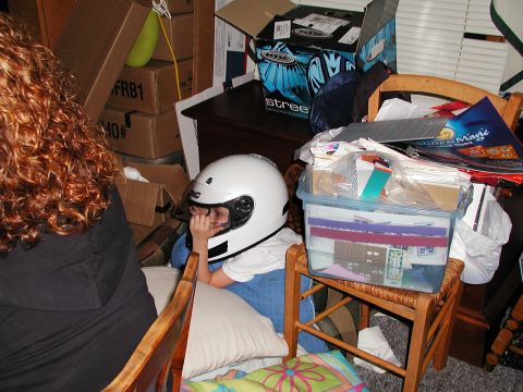 1992 Ford Taurus - Child in a white helmet sits amongst boxes and storage bins in a cluttered room.