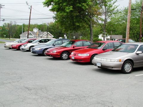 1992 Ford Taurus - A row of cars are parked in an outdoor lot on a cloudy day.