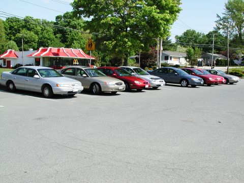 1992 Ford Taurus - Several cars are parked in a lot in front of a McDonald's restaurant.