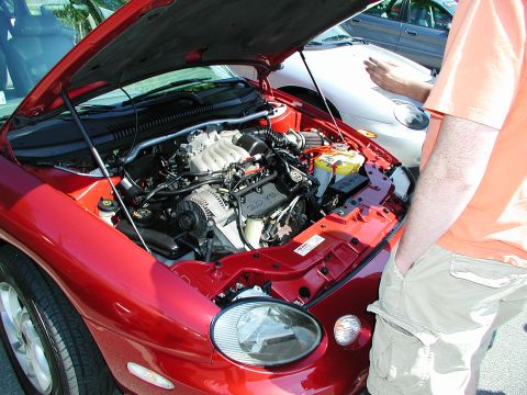 1992 Ford Taurus - Engine bay of a red car, with another vehicle in the background.