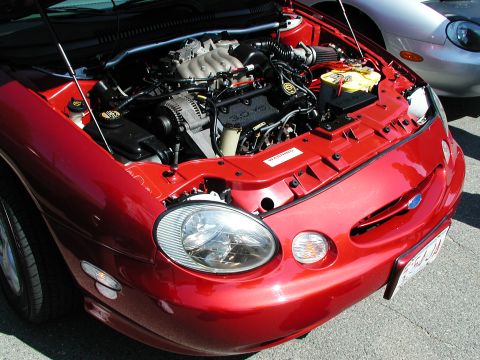 1992 Ford Taurus - The front of a red 1996 Ford Taurus is visible with its hood open, revealing the engine compartment.