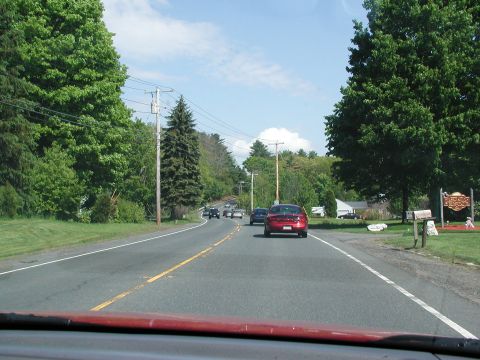 1992 Ford Taurus - Driving down a rural road on a sunny day with multiple vehicles ahead.