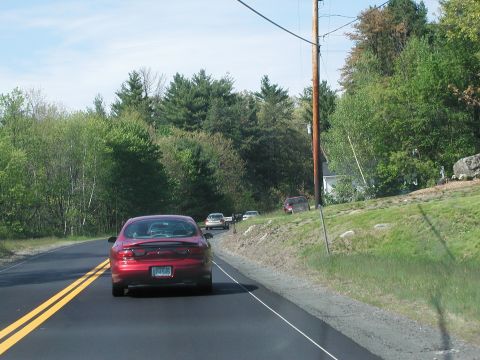 1992 Ford Taurus - A red 1992 Ford Taurus is seen from behind while driving on a two-lane road with trees lining the sides.