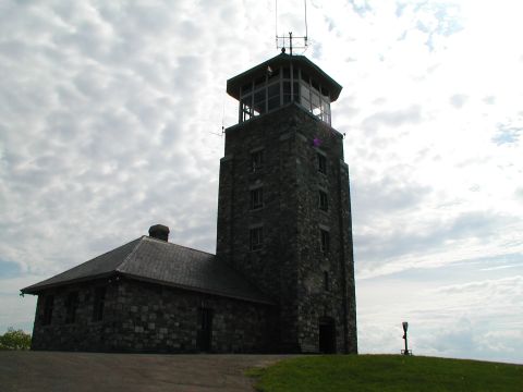 1992 Ford Taurus - A stone tower and adjacent building stand under a dramatic sky, with a watermark at the bottom right.