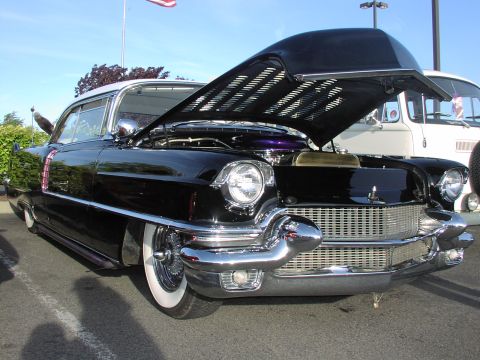 1979 Ford Bronco - Front view of a black 1955 Cadillac Coupe de Ville, hood raised, parked outdoors.
