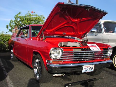 1979 Ford Bronco - A red coupe, possibly a 1966 model, is displayed with its hood open next to another vehicle.