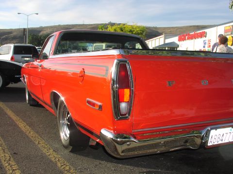 1979 Ford Bronco - Rear view of a red pickup truck with a chrome bumper and black stripe detail.