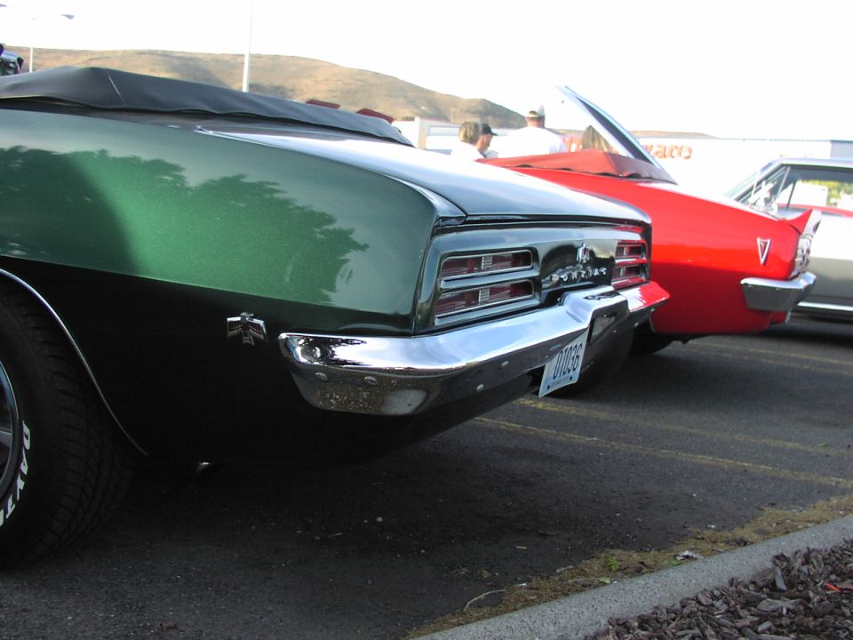 Green 1969 Pontiac Firebird convertible rear view with chrome bumper and dual taillights