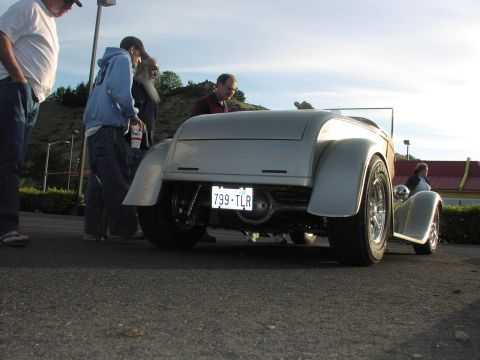 1979 Ford Bronco - A group of people admire a custom silver hot rod parked outdoors.