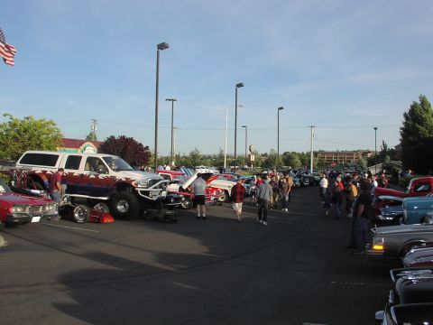 1979 Ford Bronco - A variety of vehicles are on display at an outdoor car show under a clear sky.