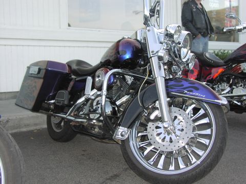 1979 Ford Bronco - A custom motorcycle with purple and blue flame paint is parked next to another bike.