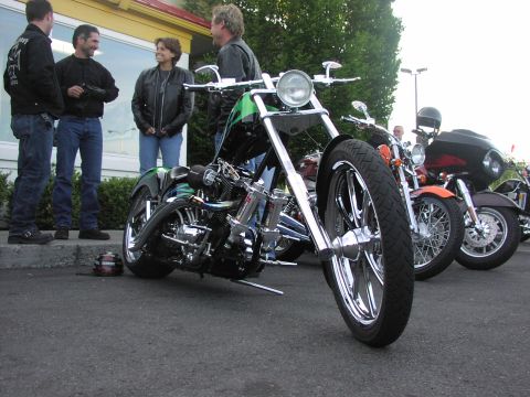 1979 Ford Bronco - Several custom motorcycles are parked outside a building with people standing nearby.