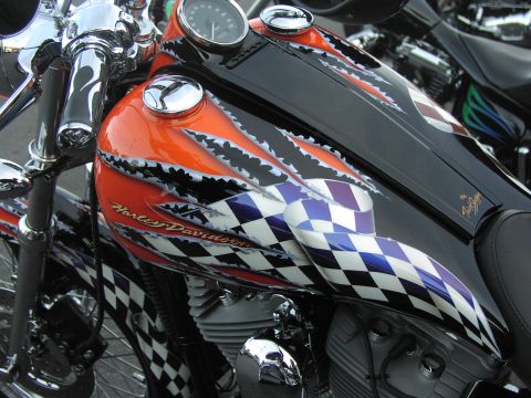 1979 Ford Bronco - A motorcycle's fuel tank displays a custom paint job flames and checkered patterns.