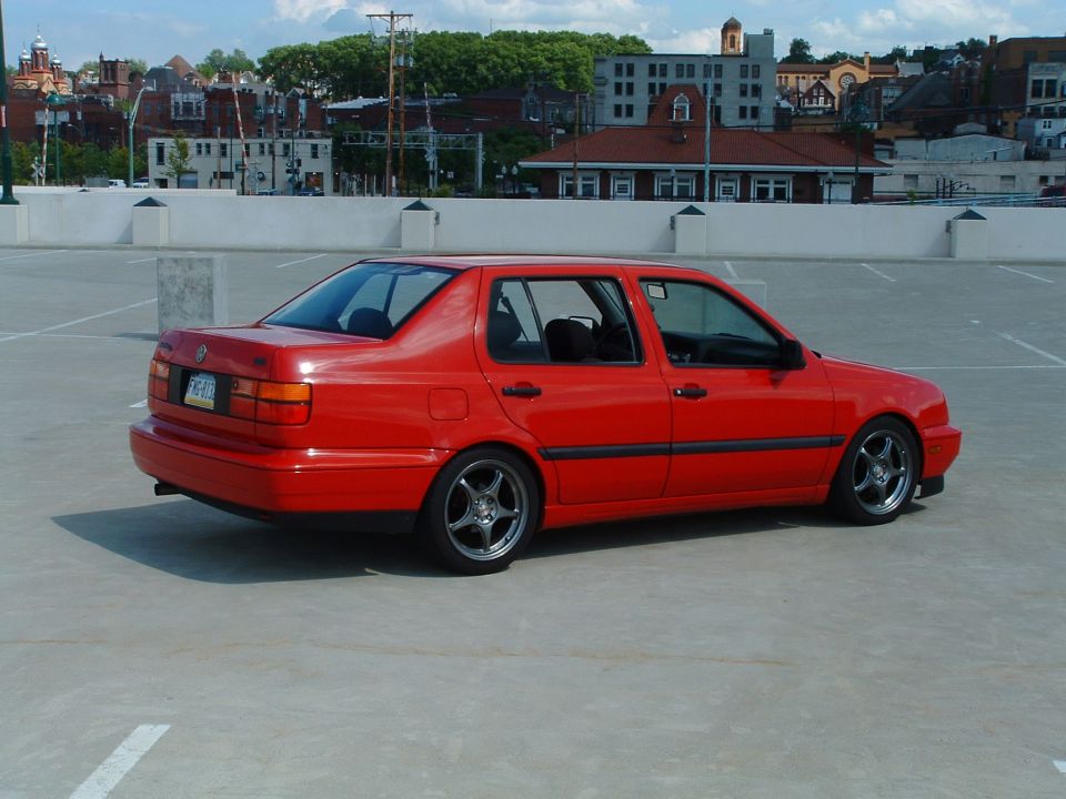 Red 1994 Volkswagen Jetta sedan parked on a rooftop