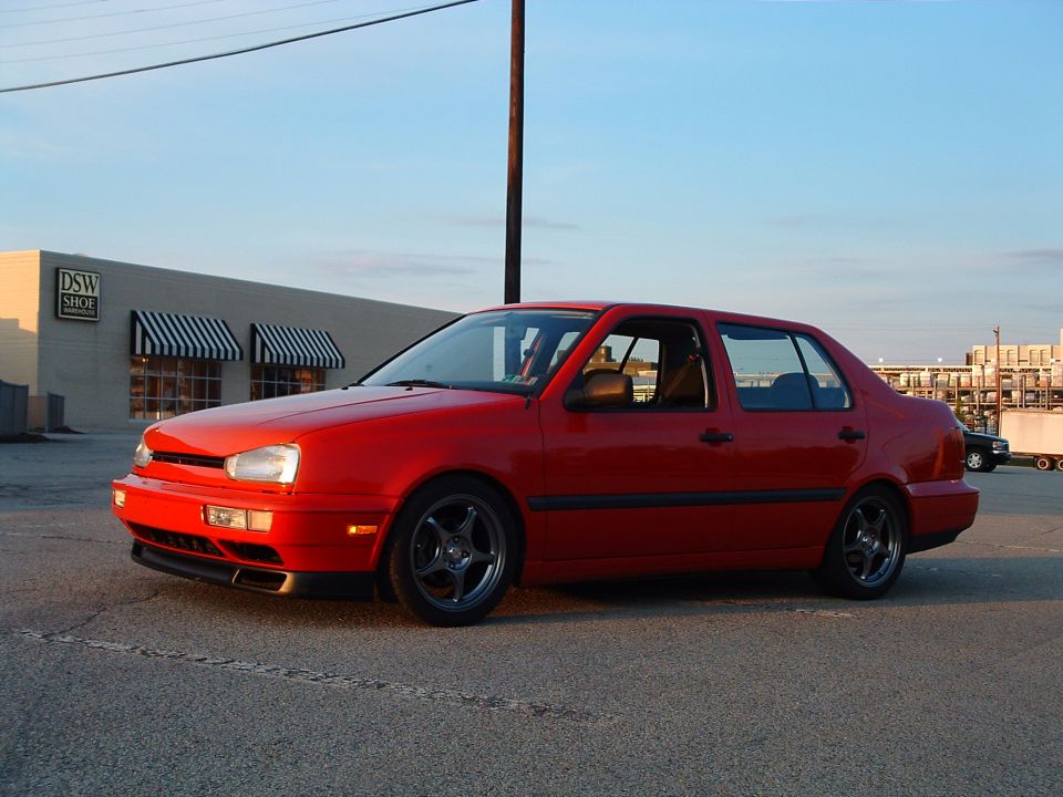 Red 1994 Volkswagen Jetta parked outside a DSW Shoe store