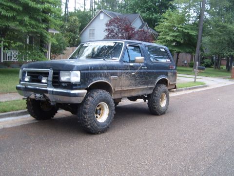 1988 Ford Bronco - This black Ford Bronco is equipped with large off-road tires and appears to be from the late 1980s.