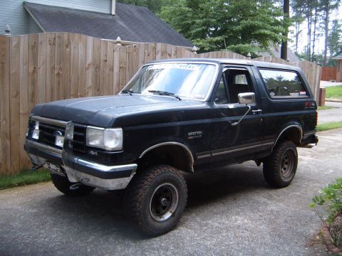 1988 Ford Bronco - This black Ford Bronco is shown from the front three-quarter angle, off-road tires and a bull bar.