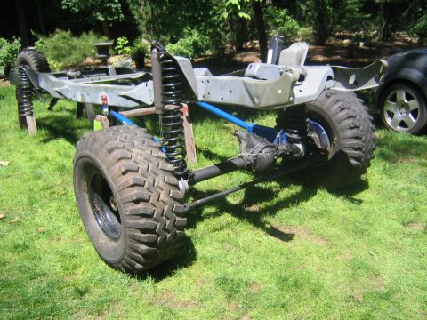 1978 Ford Bronco - Bare rolling 4x4 chassis sitting on a lawn with no body mounted: a bare-metal frame converted to coil springs and shocks at all four corner…