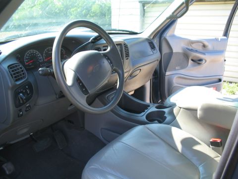 1999 Ford Expedition - The interior of a 1999 Ford Expedition, light gray upholstery and a dark gray dashboard.