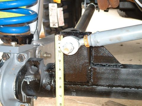 1995 Ford Bronco - Close-up of vehicle suspension components being measured, with a tape measure indicating dimensions.