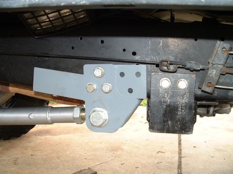 1995 Ford Bronco - Aftermarket suspension bracket installed on vehicle frame, showing bolted connections and a control arm.