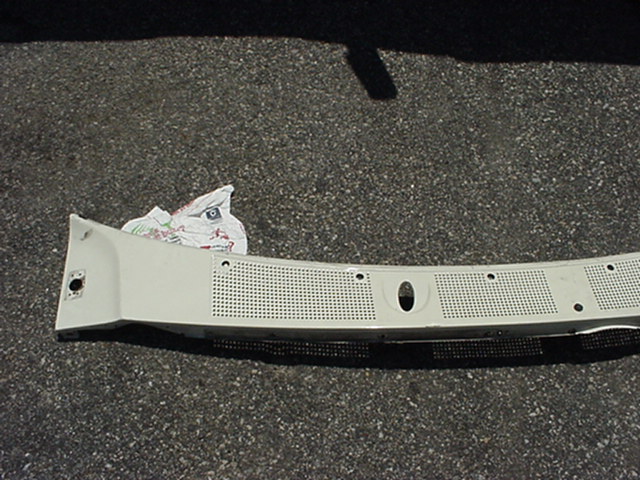 White plastic windshield cowl panel with perforated sections and mounting holes