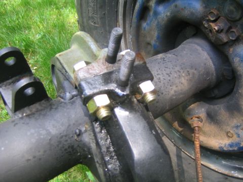 1978 Ford Bronco - Close-up of a truck's rear suspension mounting point, showing the axle tube, spring perch and U-bolts with yellow-zinc nuts, plus welded sp…