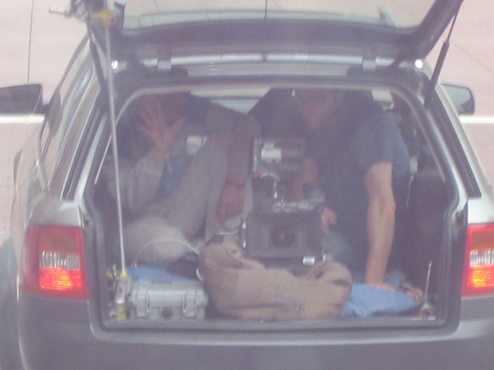 Close-up of an open station wagon hatch loaded with film camera and cases