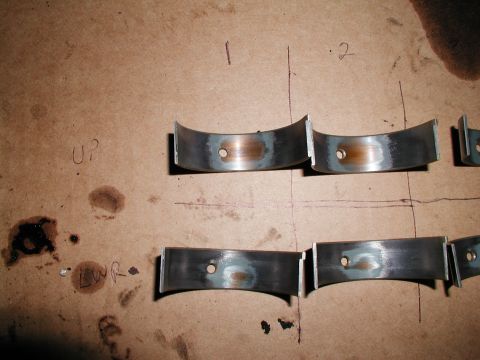 1992 Ford Taurus - Several engine rod bearings are shown on a surface marked with numbers and orientation indicators.