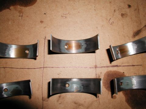 1992 Ford Taurus - Several engine rod bearings are shown on a surface, with some bearing numbers visible.