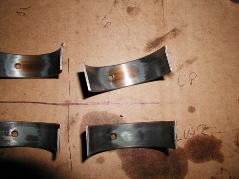 1992 Ford Taurus - Engine rod bearings are shown on a workbench, with visible wear and oil stains. Text indicates orientation.