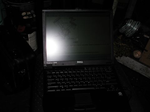 1992 Ford Taurus - Photograph of a Dell Inspiron 3500 laptop in a garage; the screen is too dark to read the displayed service document.