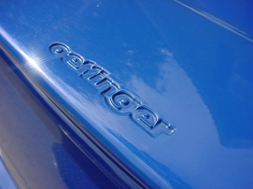 Embossed text 'Carringer' on a blue car surface