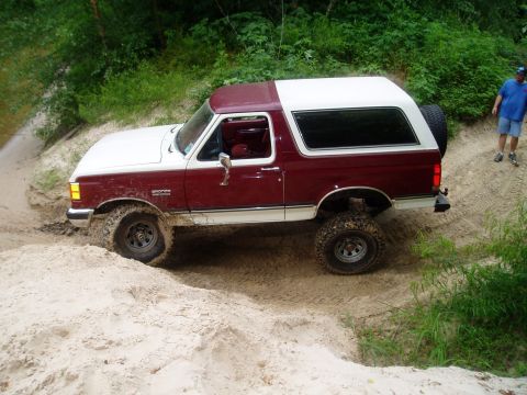 1990 Ford Bronco - This 1990 Ford Bronco is navigating a sandy off-road path.
